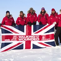 WWTW team at the North Pole holding a flag